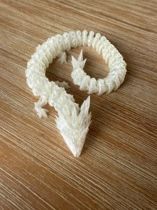 Frostbite the Ice Crystal Dragon flexi toy curled into a spiral pose