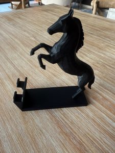 Side view of black horse phone stand showing the base that holds a phone